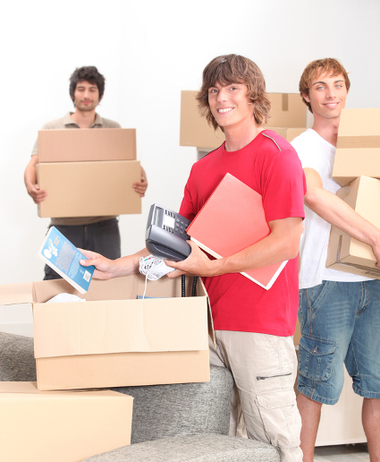 Three male friends all holding moving boxes to illustrate moving without a car